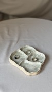 Biała ceramiczna podstawka z zielonymi plamkami