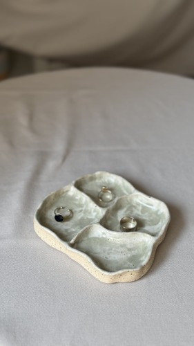 Biała ceramiczna podstawka z zielonymi plamkami