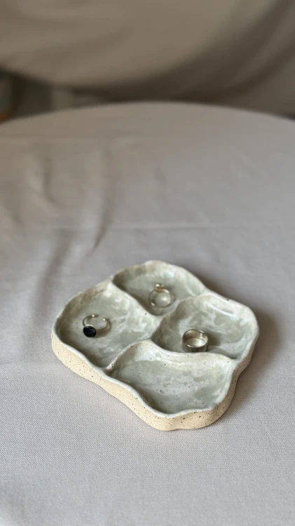 Biała ceramiczna podstawka z zielonymi plamkami