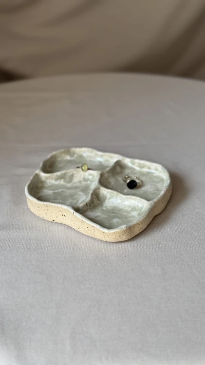 Biała ceramiczna podstawka z zielonymi plamkami