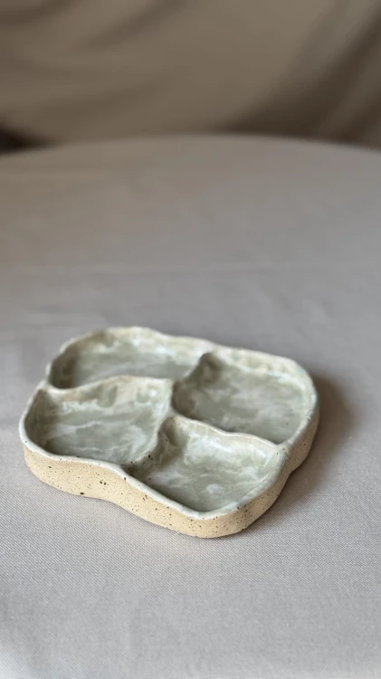 Biała ceramiczna podstawka z zielonymi plamkami