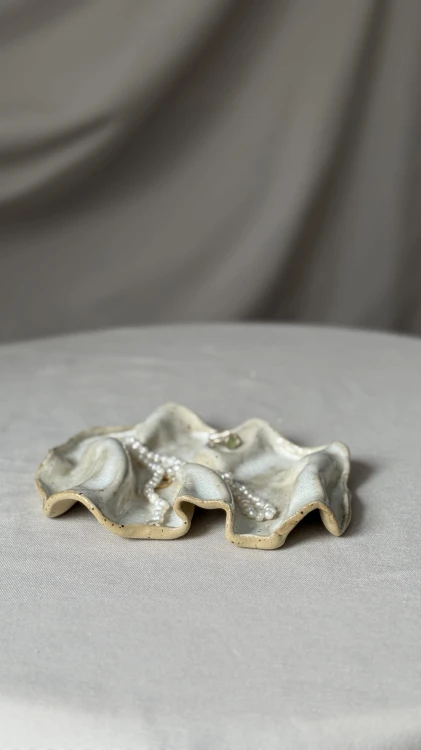 Minimalistyczna biała podstawka ceramiczna o falowanej formie