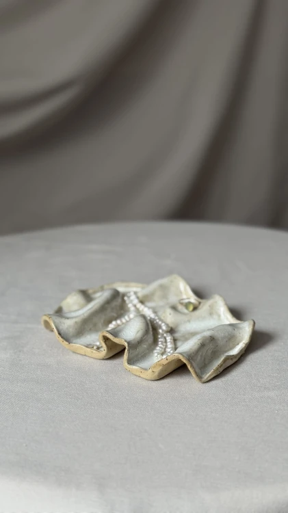 Minimalistyczna biała podstawka ceramiczna o falowanej formie