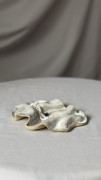 Minimalistyczna biała podstawka ceramiczna o falowanej formie